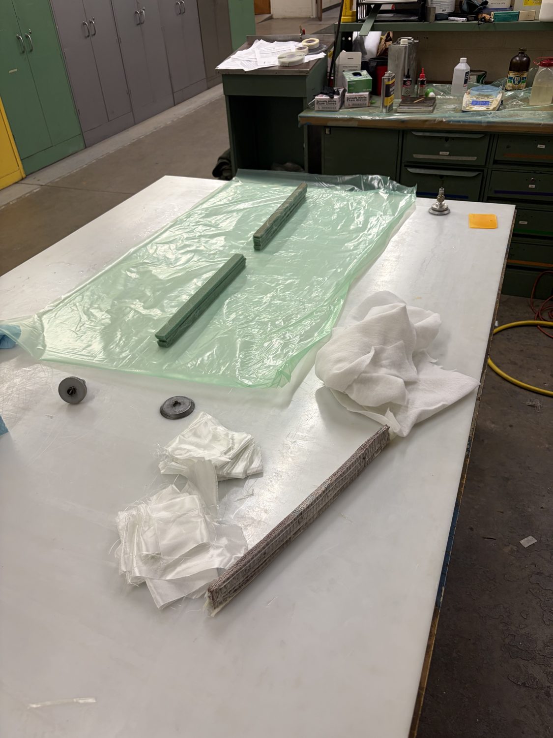 Composite beam layup on a work table under vacuum film