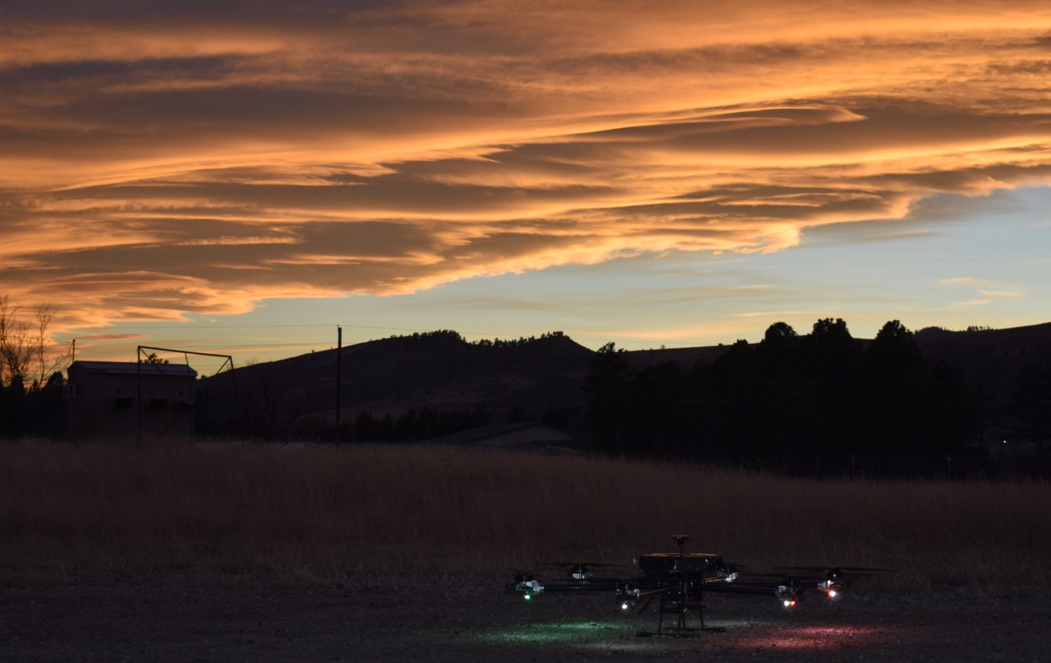 The hexacopter on the ground at dusk with its motor-mount lights lit