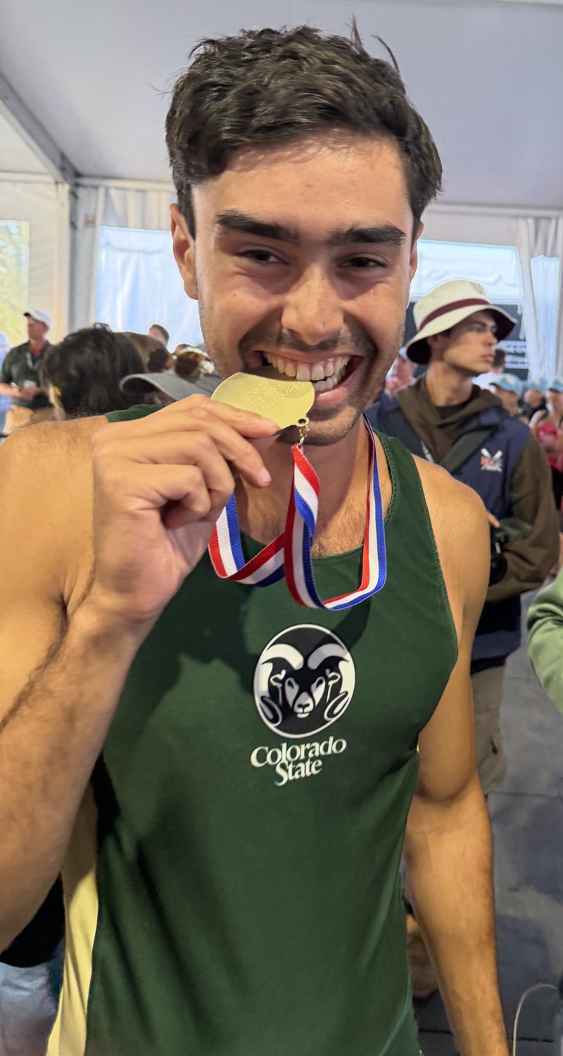 Wallace biting a gold medal in a Colorado State rowing uniform